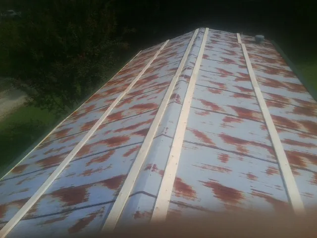 Rusted metal roof panels with new wood purlins before replacement — Storm Damage Roof Repair in Bella Vista by Roofing Brothers