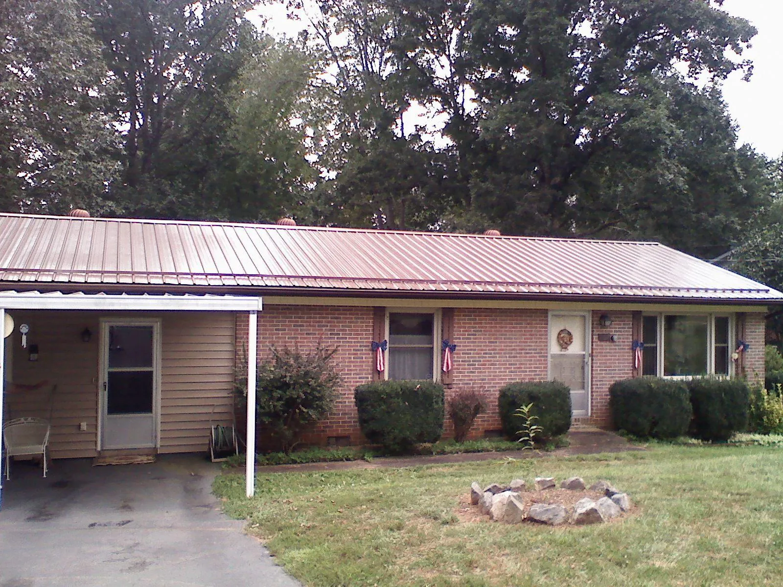 Bronze metal roof and carport on a brick ranch home — Roof Repair work by our crew in Bella Vista
